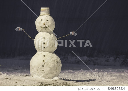 Tall snowman at winter night in the park outdoors. Tall snowman at winter night in the park outdoors. 84989884