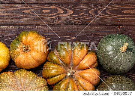 Assortment of small pumpkins on wooden background Assortment of small pumpkins on wooden background 84990037