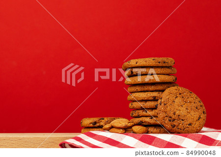 Chocolate chip cookies in stack on red background Chocolate chip cookies in stack on red background 84990048