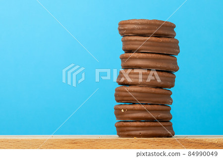 Stack of glazed chocolate cookies on blue background Stack of glazed chocolate cookies on blue background 84990049