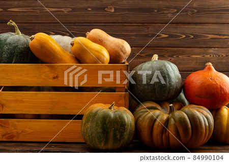 Pile of pumpkins in a wooden box Pile of pumpkins in a wooden box 84990104