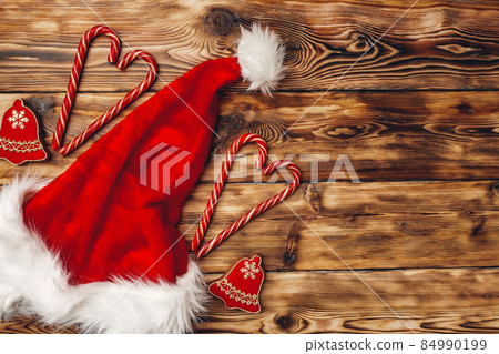 Santa Claus cap and Christmas gift on wooden background top view 84990199