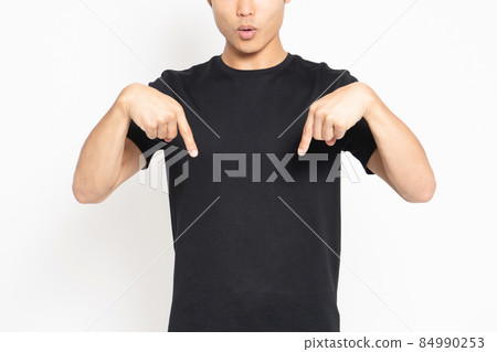 穿著黑色 T 恤的年輕人站在白色背景前,顯示點 穿著黑色 T 恤的年輕人站在白色背景前,顯示點 84990253