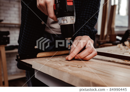 Close up of a carpenter drilling a hole in timber 84990445
