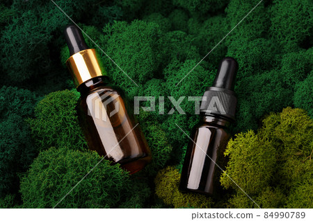 Set of brown glass bottles beauty products on moss background Set of brown glass bottles beauty products on moss background 84990789
