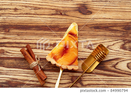 Slice of an apple tart pie on wooden table Slice of an apple tart pie on wooden table 84990794