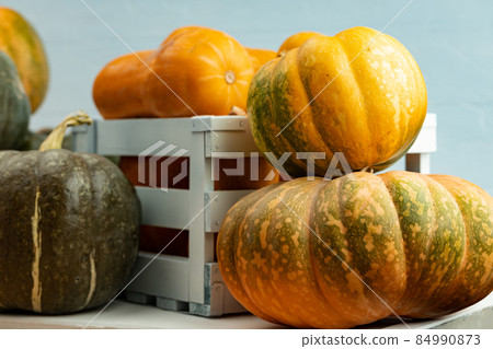 Pile of pumpkins in a wooden box 84990873