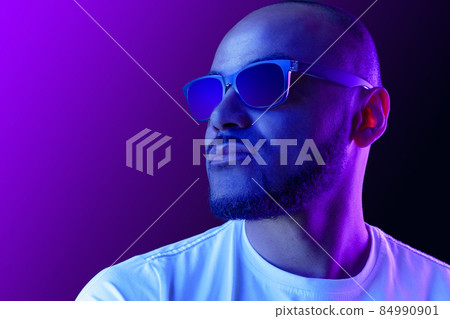 Portrait of afro american man model in glasses in neon light Portrait of afro american man model in glasses in neon light 84990901