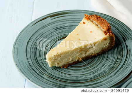 Piece of classic cheesecake on green plate Piece of classic cheesecake on green plate 84991479