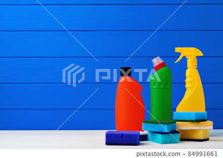 Various cleaning items against blue wooden background 84991661