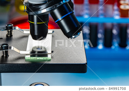 Microscope with blood samples test tubes close up 84991708