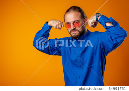 Bearded man in shirt showing bicep and looking at camera 84991761
