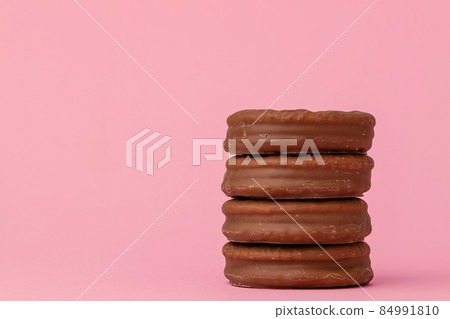 Stack of chocolate cookies against pink background Stack of chocolate cookies against pink background 84991810
