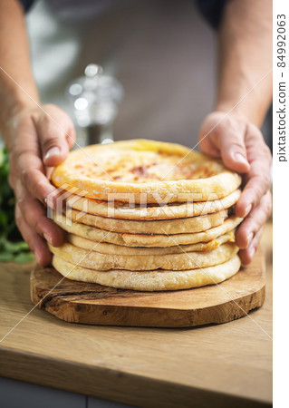 Man holding khachapuri is cheese bread, traditional caucasian food Man holding khachapuri is cheese bread, traditional caucasian food 84992063