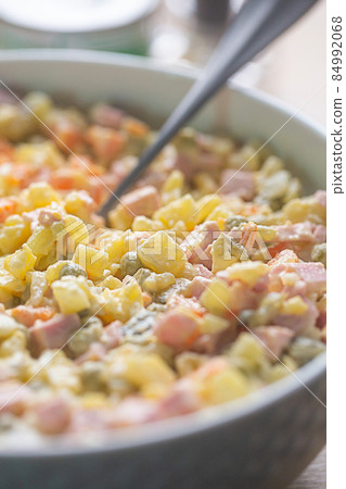 Russian traditional salad olivier with pea on wooden background, close up Russian traditional salad olivier with pea on wooden background, close up 84992068