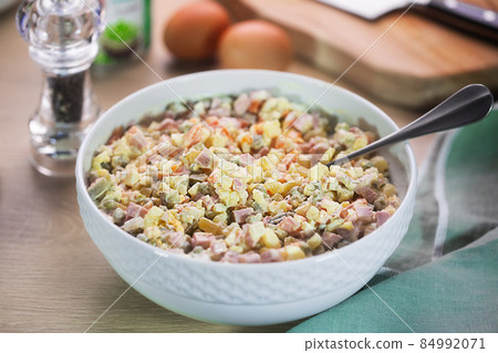 Large bowl of Russian traditional salad olivier with pea on wooden background 84992071