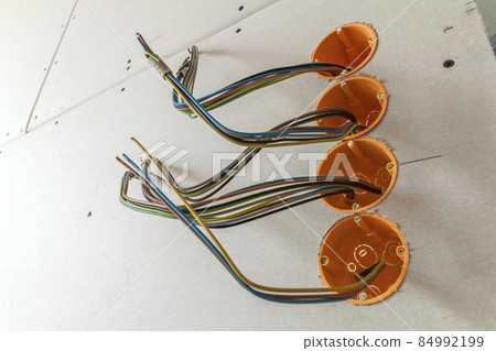 New electrical installation, socket plastic boxes and electrical cables on the wall, renovation concept. Electrical wiring installation. New electrical installation, socket plastic boxes and electrical cables on the wall, renovation concept. Electrical wiring installation. 84992199