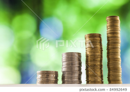 Growing coins stacks with green and blue sparkling bokeh background. Financial growth, saving money, business finance wealth and success concept. 84992649