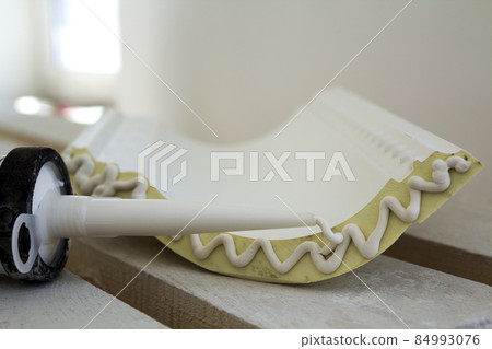 Close-up detail of decoration molding with glue adhesive before installation in interior renovation. 84993076
