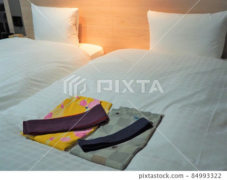 A pair of colored yukatas placed on the bed in the twin room A pair of colored yukatas placed on the bed in the twin room 84993322