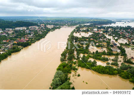 Aerial view of Dnister river with dirty water and flooded houses in Halych town, western Ukraine. Aerial view of Dnister river with dirty water and flooded houses in Halych town, western Ukraine. 84993972