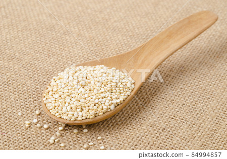 Raw, whole, unprocessed quinoa seed in wooden spoon. Raw, whole, unprocessed quinoa seed in wooden spoon. 84994857