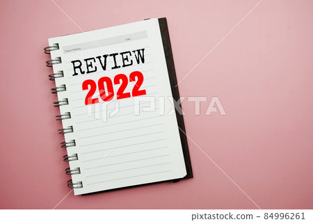 Review 2022 text on paper notebook top view on pink background Review 2022 text on paper notebook top view on pink background 84996261