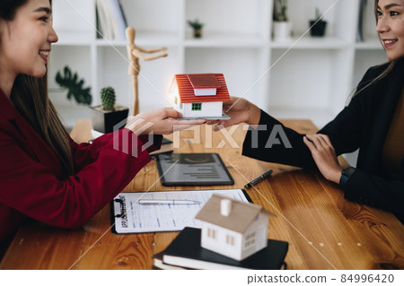 Agents are giving house to customer after sign agreement contract at agency office. Agreement and Real estate concept. 84996420