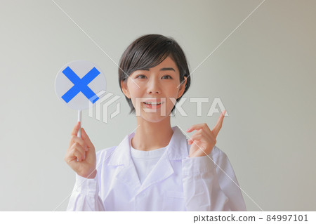 White coat female 2 in a one-point pose holding an X plate 84997101