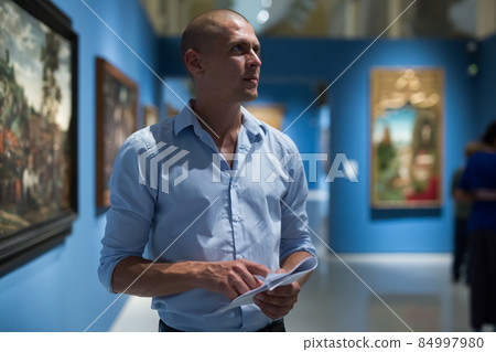 Man standing in picture gallery 84997980