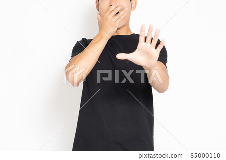 A man in a black T-shirt standing in front of a white background and making a surprised pose A man in a black T-shirt standing in front of a white background and making a surprised pose 85000110