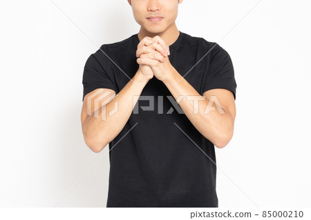 一個穿著黑色 T 恤的男人站在白色背景前,手拉著手 一個穿著黑色 T 恤的男人站在白色背景前,手拉著手 85000210
