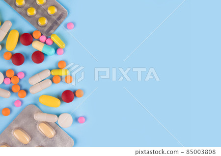 Assorted multicolored medicine pills, capsules and tablets on blue background with copy space. Immune system vitamins and supplemets. Dietary bio supplements Assorted multicolored medicine pills, capsules and tablets on blue background with copy space. Immune system vitamins and supplemets. Dietary bio supplements 85003808