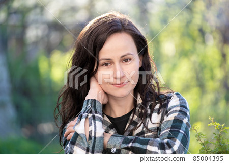Portrait of pretty young woman relaxing outdoors on warm spring sunny day. Portrait of pretty young woman relaxing outdoors on warm spring sunny day. 85004395