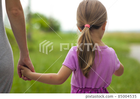 Little girl holding a hand of her mother. Family relations concept. Little girl holding a hand of her mother. Family relations concept. 85004535