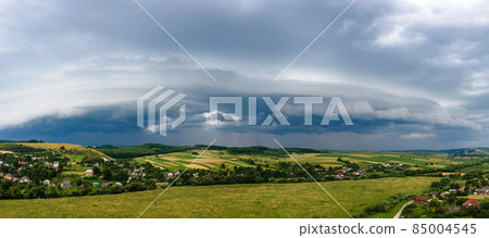 Landscape of dark clouds forming on stormy sky during thunderstorm over rural area. 85004545