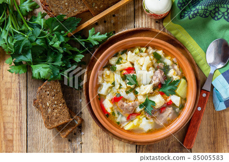 Traditional Hungarian thick soup with beef, vegetables and dumplings on a wooden table. Hot dinner or lunch. Flat lay, top view. 85005583