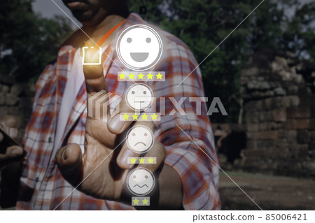 A man touching check mark icon and face emoticon smile on dark background.Customer service, service mind,service rating.Photo concept of satisfaction survey and smiling face icons time. A man touching check mark icon and face emoticon smile on dark background.Customer service, service mind,service rating.Photo concept of satisfaction survey and smiling face icons time. 85006421