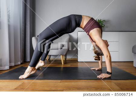 Young fitness woman doing morning yoga routine at home. 85006714