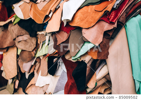 Background made of many pieces of natural leather of high quality in the manufactory. Materials for handmade leather craft. Selective focus 85009502