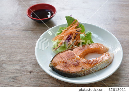 grilled salmon steak dipping teriyaki sauce with fresh vegetable salad on plate grilled salmon steak dipping teriyaki sauce with fresh vegetable salad on plate 85012011