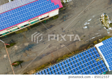 Blue photovoltaic solar panels mounted on industrial building roof for producing clean ecological electricity. Production of renewable energy concept. 85012337