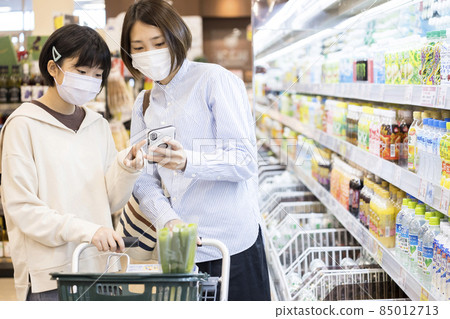 母女在超市檢查智能手機 85012713