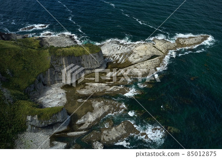 Aerial  shot of Cape Stolbchaty on Kunashir Island at low tide on a sunny day. Volcanic formations of the seabed are clearly visible. It is a unique geological formation.is included in Unesco 85012875