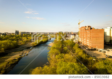 Aerial view of tall residential apartment buildings under construction and Bystrytsia river in Ivano-Frankivsk city, Ukraine. 85013082