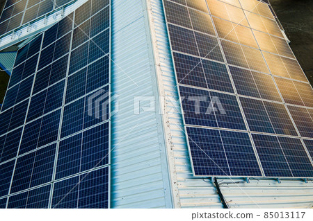 Aerial view of surface of blue photovoltaic solar panels mounted on building roof for producing clean ecological electricity. Production of renewable energy concept. Aerial view of surface of blue photovoltaic solar panels mounted on building roof for producing clean ecological electricity. Production of renewable energy concept. 85013117
