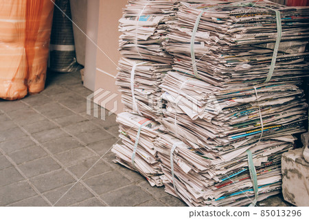 Waste paper piles on the street. Sorting garbage in everyday life. Stacks of old newspapers waiting to be picked up by garbage truck. Recycling concept. Selective focus, copy space Waste paper piles on the street. Sorting garbage in everyday life. Stacks of old newspapers waiting to be picked up by garbage truck. Recycling concept. Selective focus, copy space 85013296