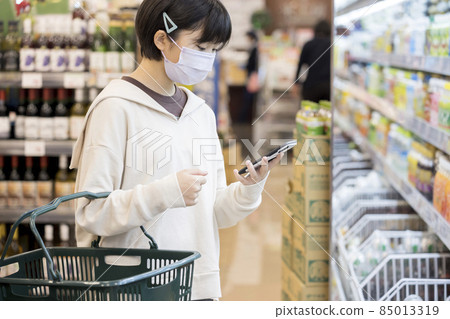 戴著口罩購物的小學生在超市看智能手機 85013319