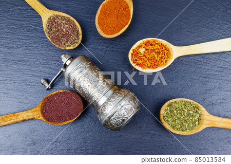Set of different aromatic spices and spice mill on black slate. Top view Set of different aromatic spices and spice mill on black slate. Top view 85013584