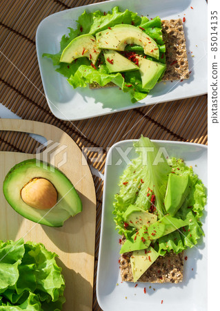 Healthy Homemade Avocado Toast with Salt lettuce leaves. Whole food concept. Vertical photo Healthy Homemade Avocado Toast with Salt lettuce leaves. Whole food concept. Vertical photo 85014135
